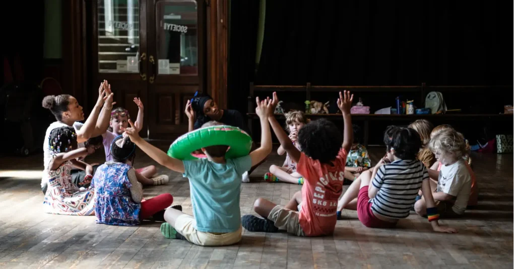 Cherry Stars team member leading a drama workshop with a group of children sitting in a circle at Stanley Arts.